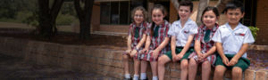 Good Shepherd Hoxton Park students sitting on bench at school